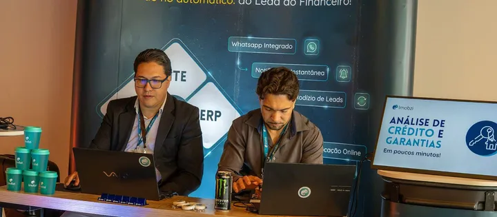 Notebooks e painel de indicadores em uso durante o evento