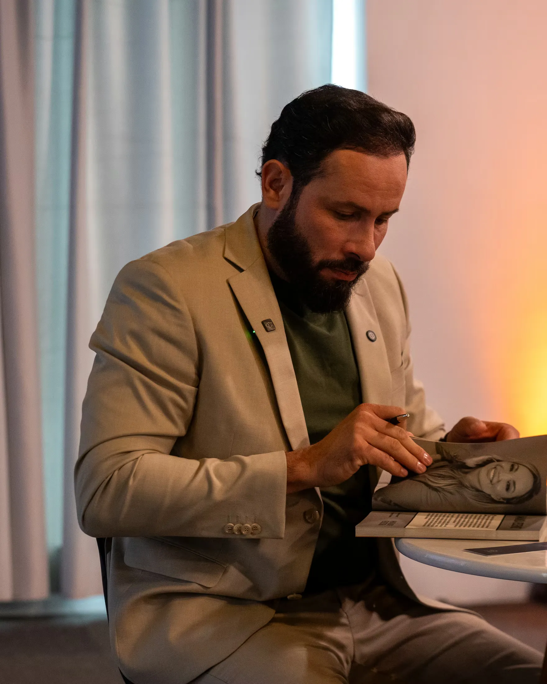 Alessandro Miranda sentado, organizando o material da imersão